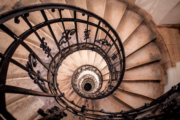 Spiral staircase illustrating helical motion, conceptually representing the angled tooth geometry used in helical gear systems.