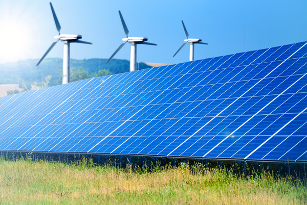 Solar panels and wind turbines generating renewable energy, representing the environmental and industrial impacts of the global energy transition.