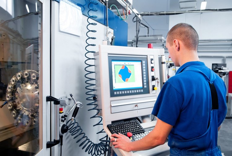 Technician operating a CNC machining center to manufacture high-precision industrial components.