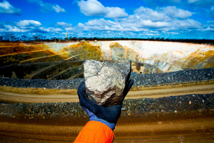 Mining professional overlooking a large open-pit mine, representing sustainable mining practices and environmental management.